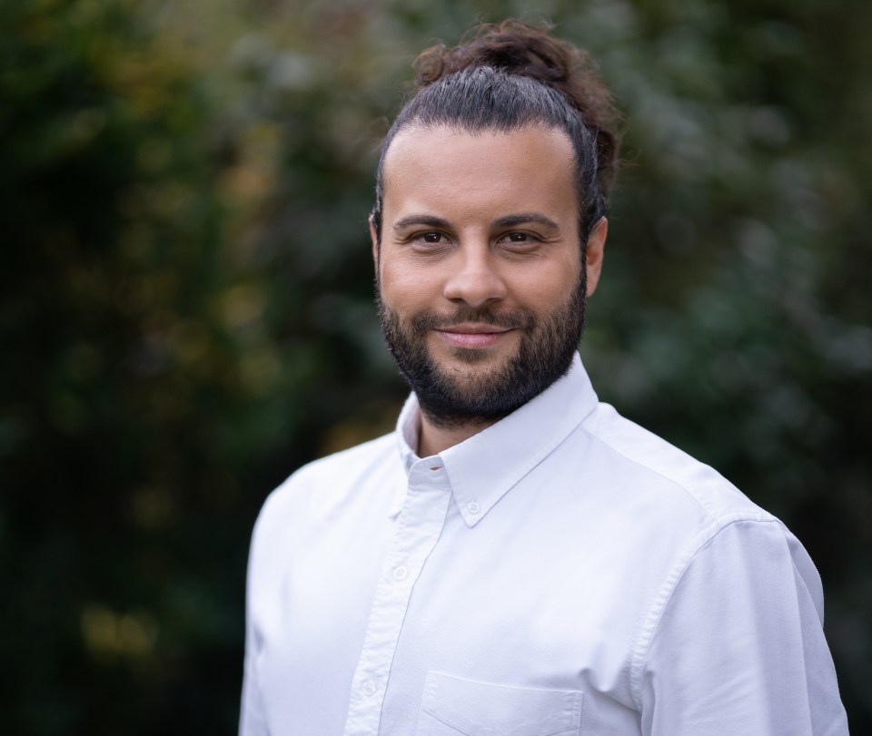 a man with a beard is wearing a white shirt