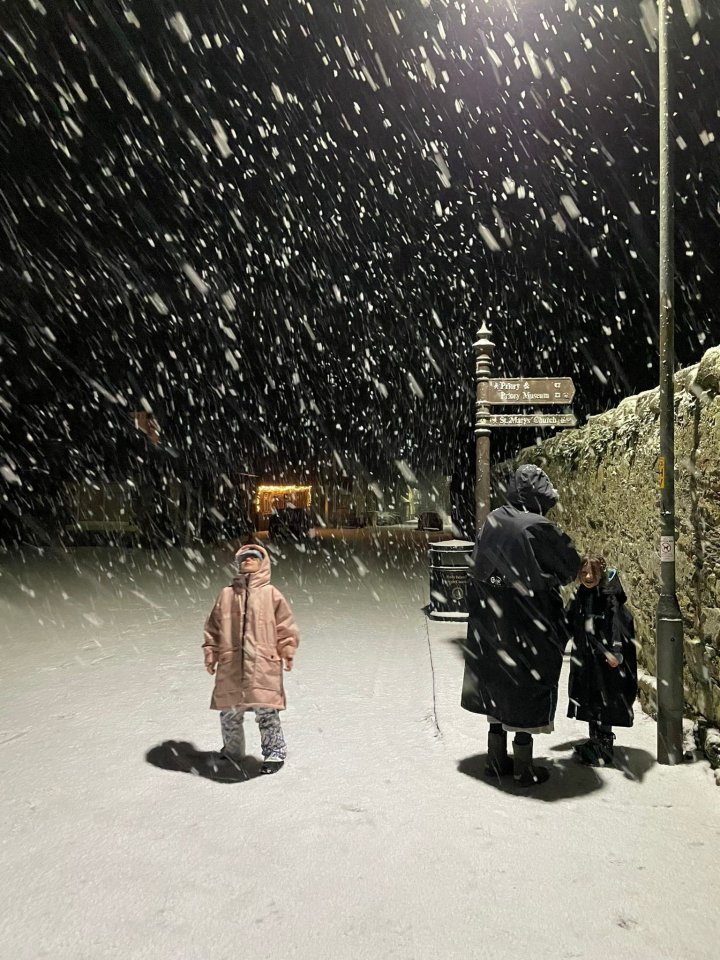 people walking in the snow near a sign that says ' castle ' on it