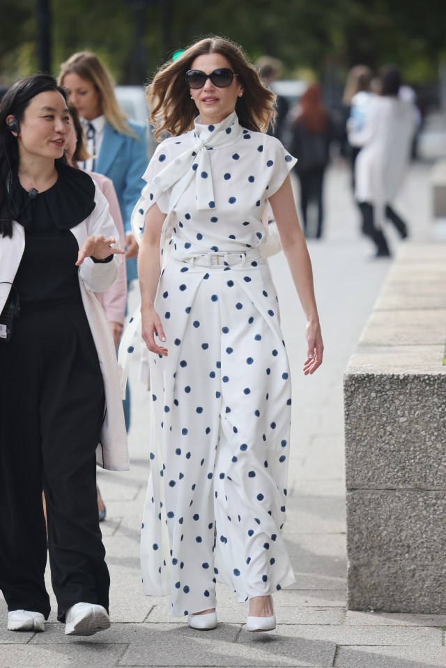 a woman in a polka dot dress walks down the street