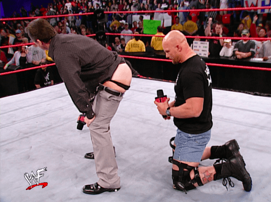 a man kneeling down in a wrestling ring with a we logo on the bottom