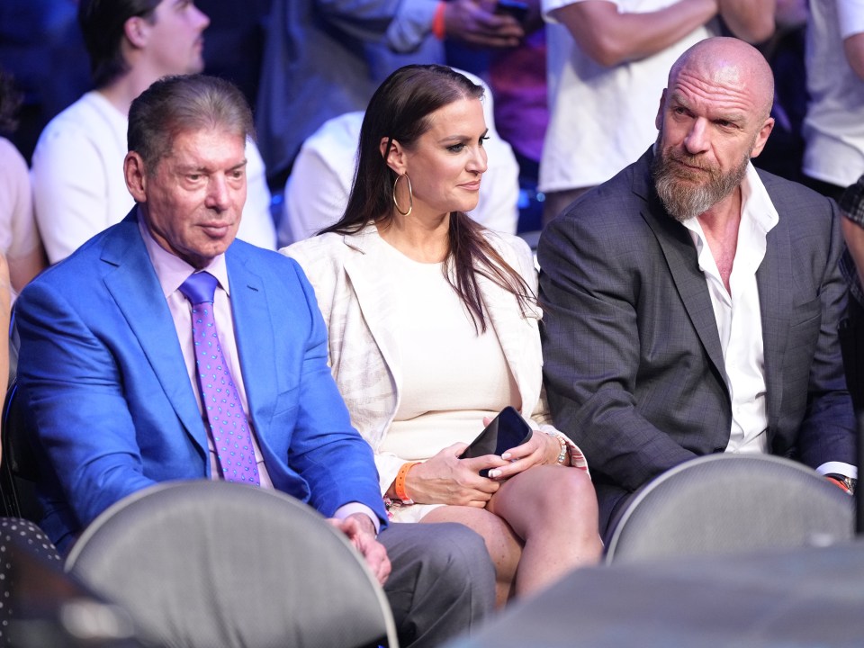 a man in a blue suit sits next to a woman in a white dress