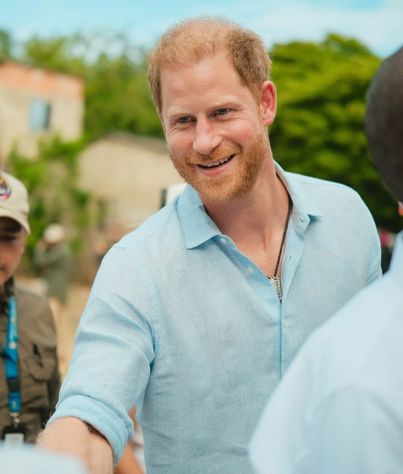 a man with a beard wearing a light blue shirt is smiling