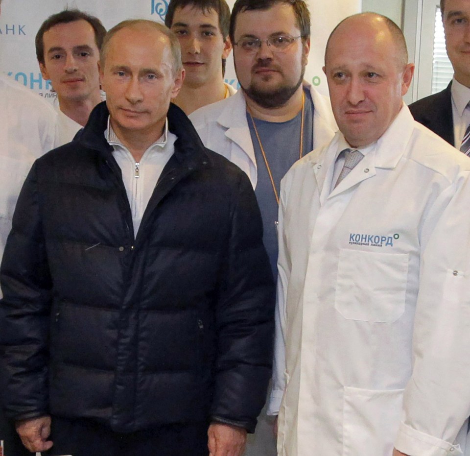 a group of men are posing for a picture with one man wearing a white coat that says конкорд