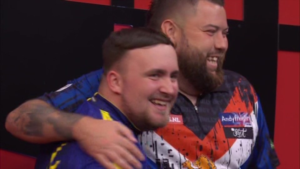 two men are posing for a picture and one has the word andy on his shirt