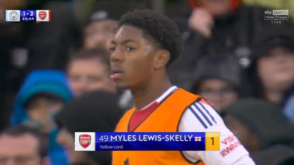 a soccer player wearing an orange vest is standing in front of a crowd .