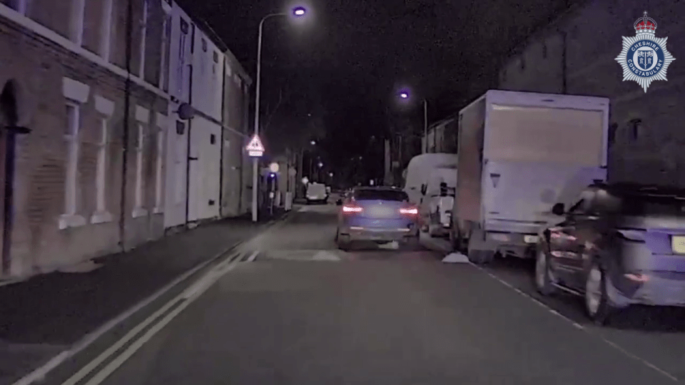 a police car is driving down a street at night