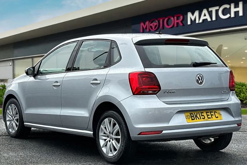 a silver volkswagen polo is parked in front of a motor match store