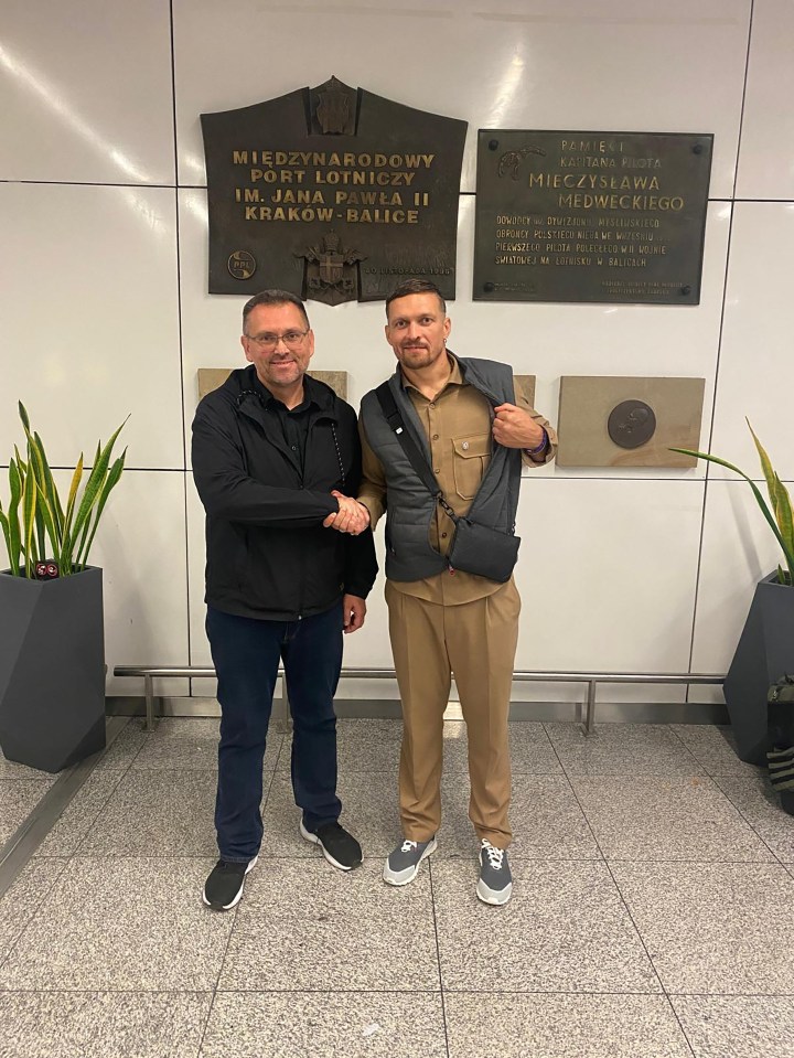 two men shaking hands in front of a plaque that says port lotniczy