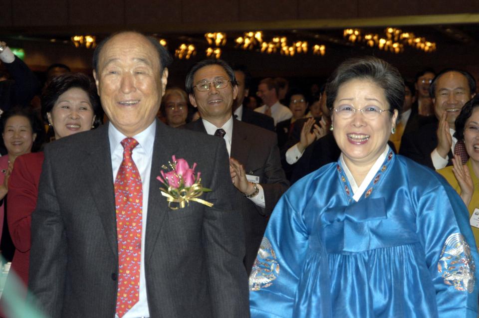 a man in a suit and tie stands next to a woman in a blue dress