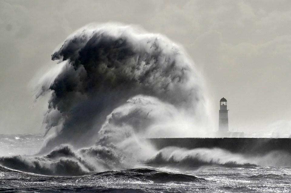 Waves crash against the lighthouse in Seaham Harbour, County Durham