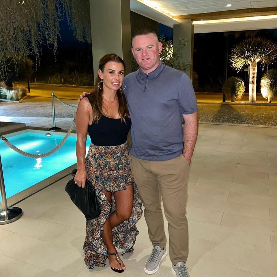 a man and woman pose for a picture in front of a pool