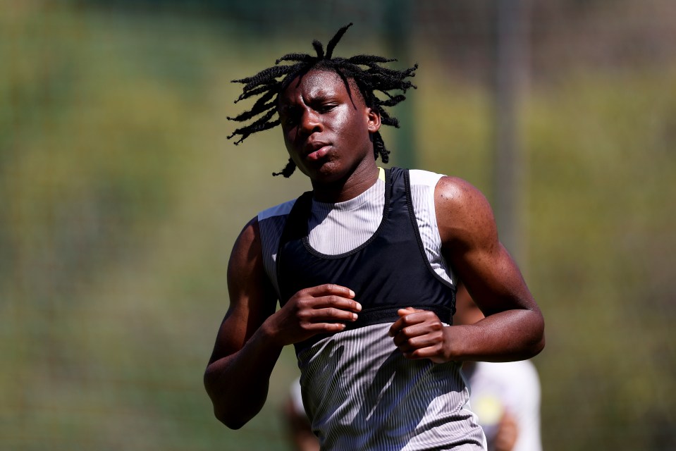 a man with dreadlocks is running on a field