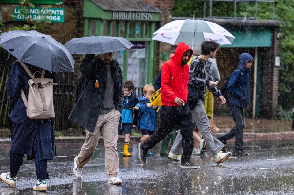 Wet and windy weather in London on the Friday commute to school and work after days of heavy rain