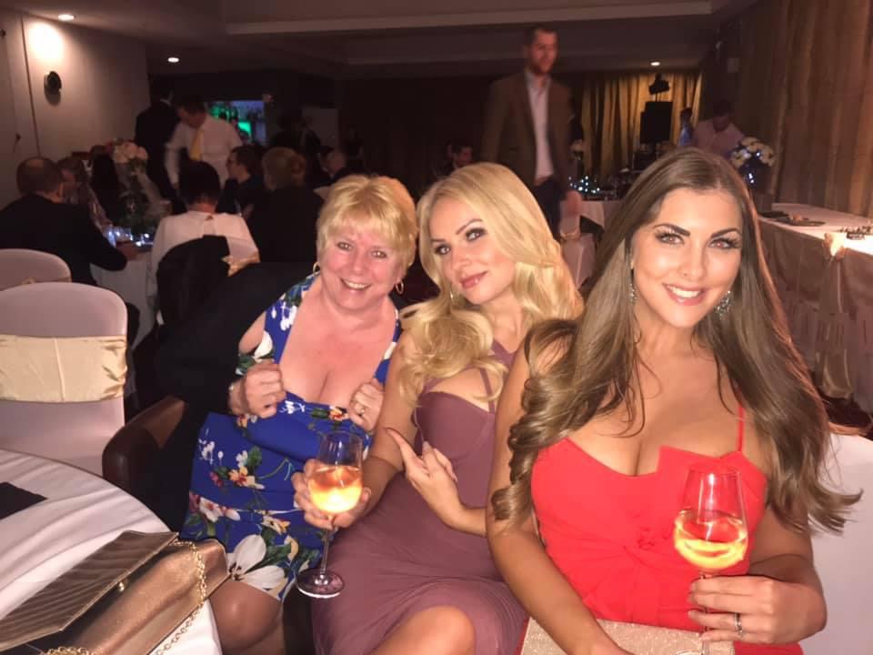 three women are posing for a picture while holding wine glasses