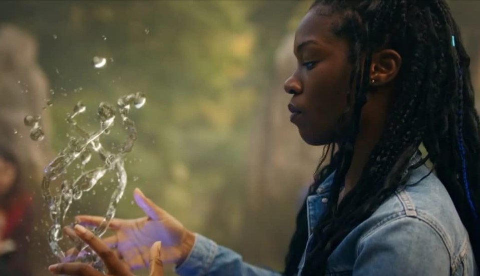 a woman in a denim jacket is holding water in her hands