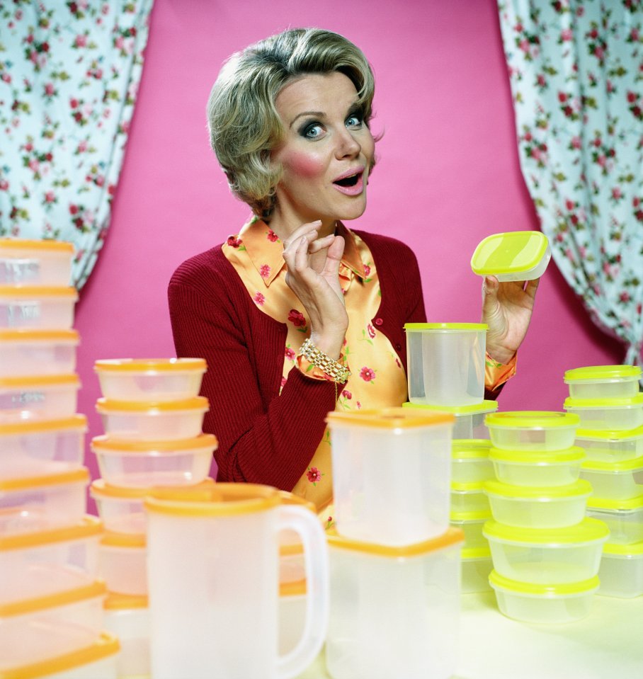 a woman is standing in front of a table full of plastic containers