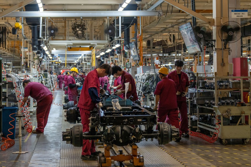 Workers work on a vehicle assembly line at a light truck workshop of Anhui Jianghuai Automobile Group Co LTD in Hefei, China