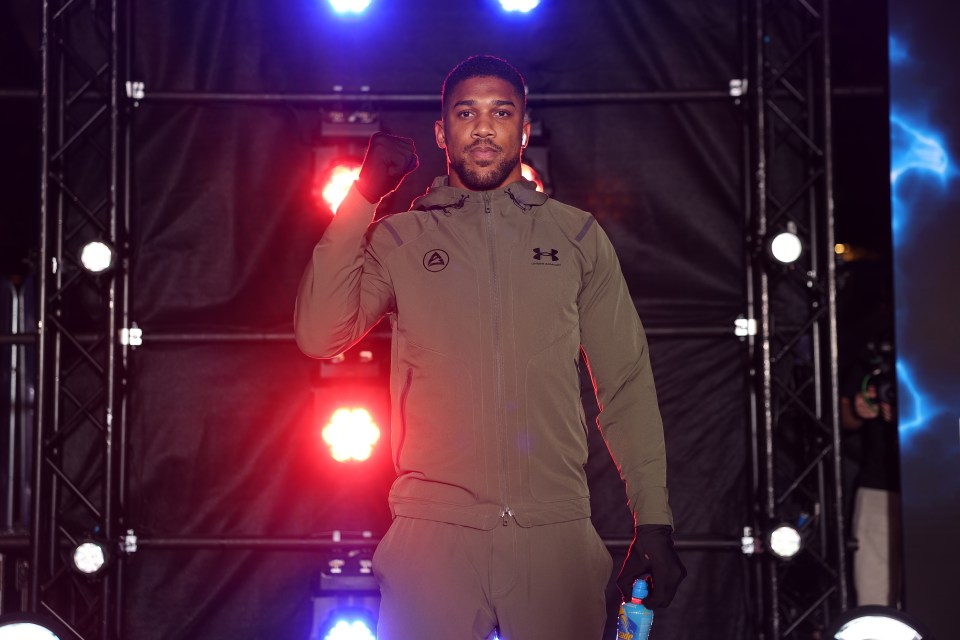 a man in an under armour jacket stands in front of a stage