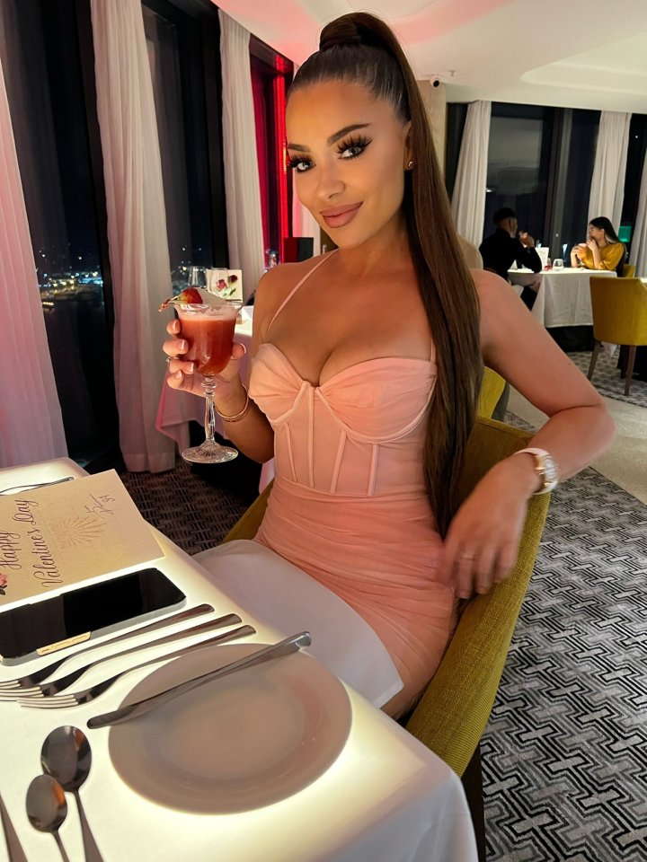 a woman sits at a table with a menu that says happy valentine 's day