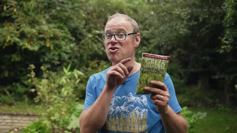 a man holding a book titled green adventures