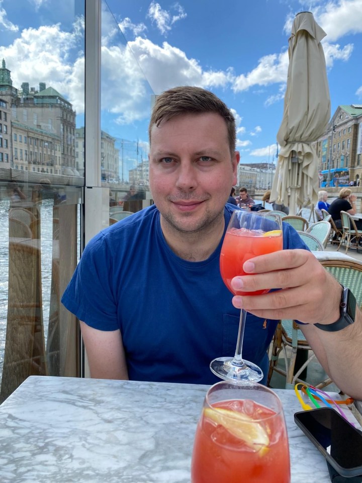 a man sitting at a table with a drink in his hand