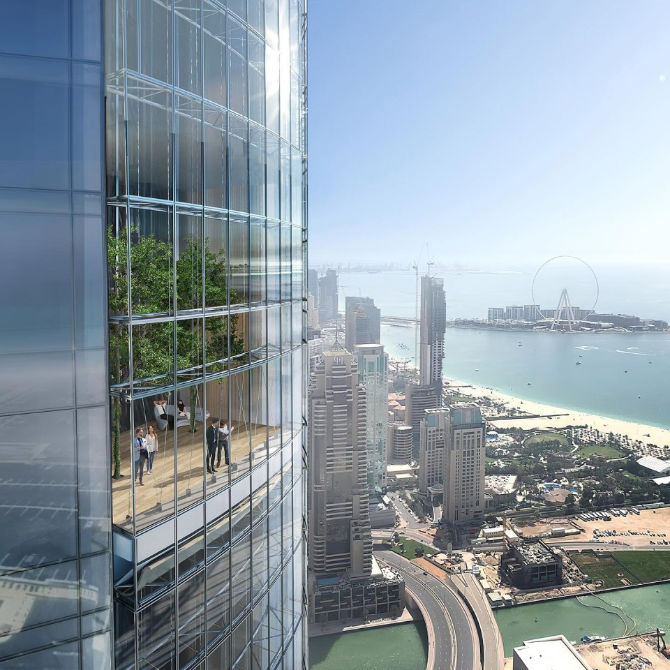 a group of people standing on a balcony on the side of a tall building