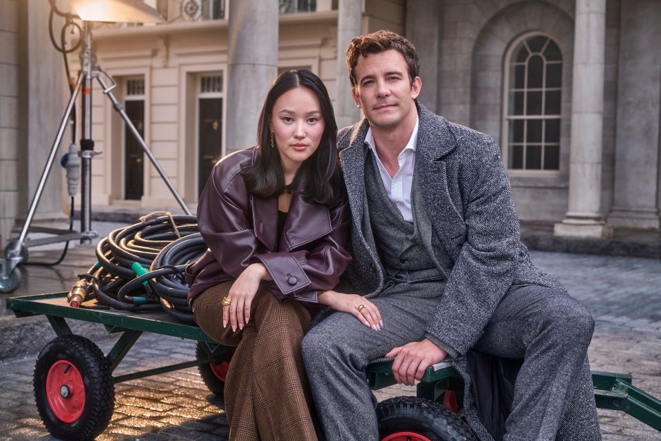 a man and a woman sit on a green cart