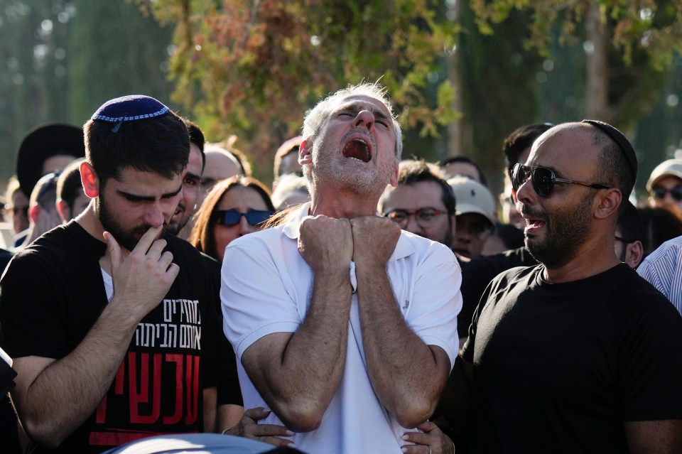 Yigal Sarusi, centre, at the funeral of his son, hostage Almog Sarusi who was killed by Hamas in the Gaza Strip