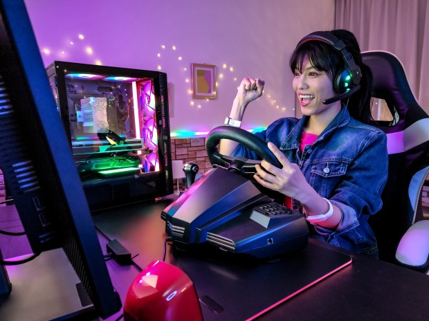 a woman wearing headphones and a steering wheel is playing a video game