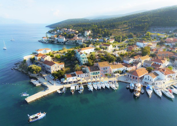 an aerial view of a small town with boats docked in the water