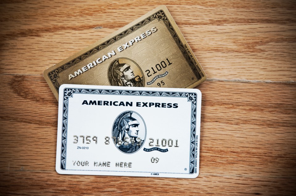 two american express cards on a wooden table