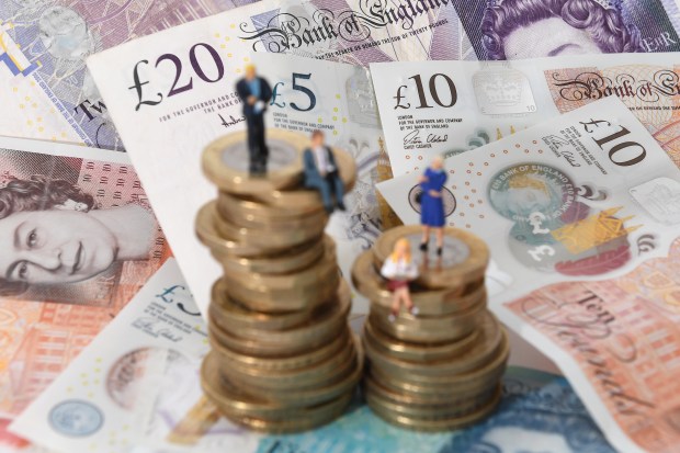 a stack of coins sits on top of a pile of british money