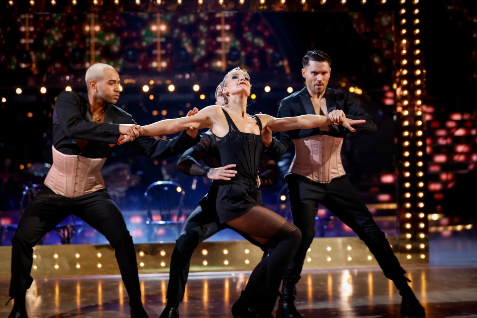 a man and a woman are dancing on a stage with the letter m behind them