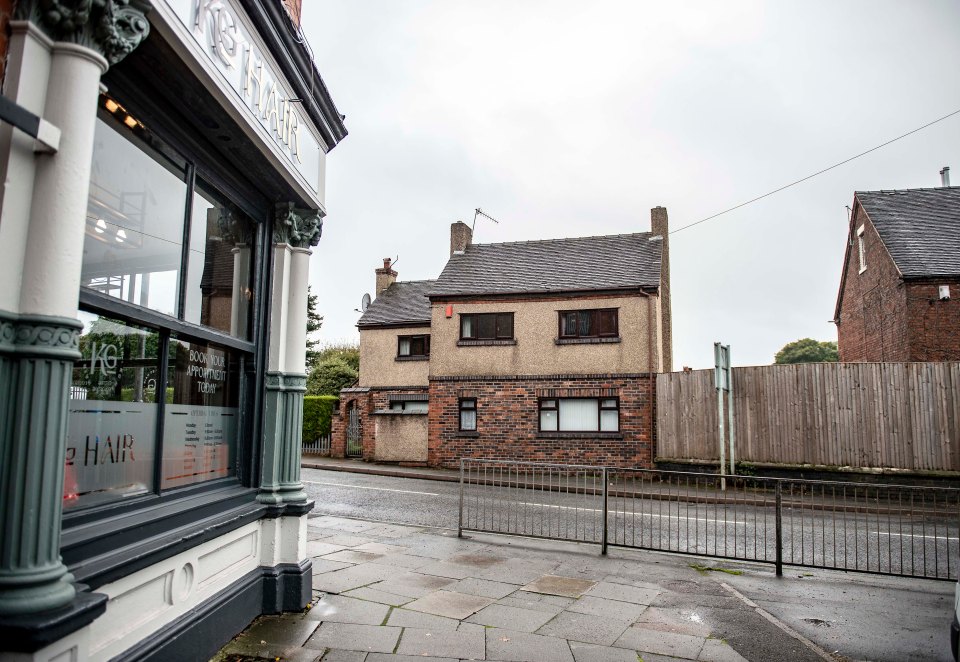 The illegally erected wooden barrier, which stands half the height of the house