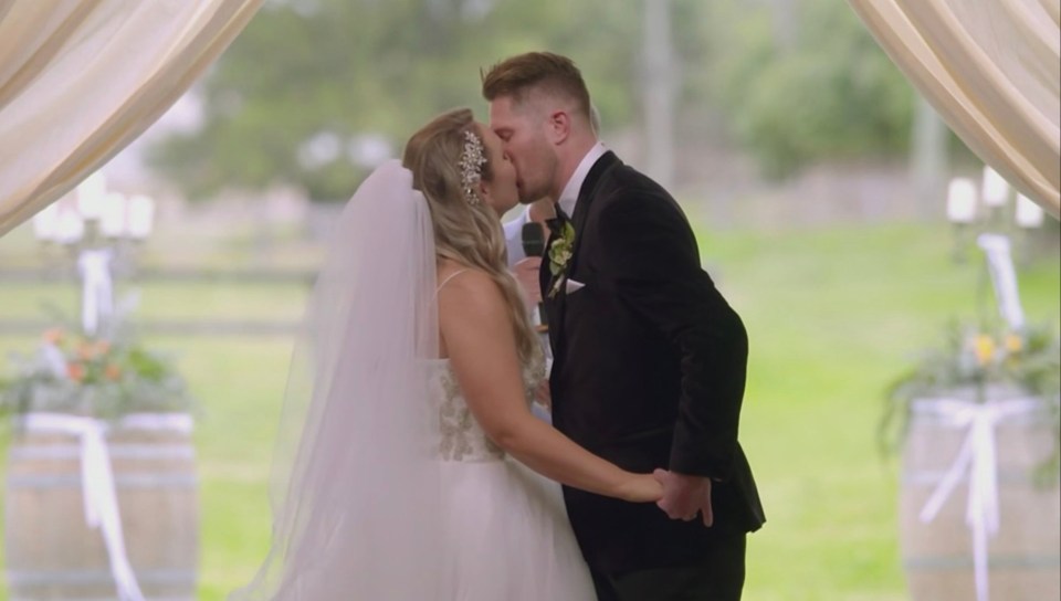 a bride and groom kiss during their wedding ceremony