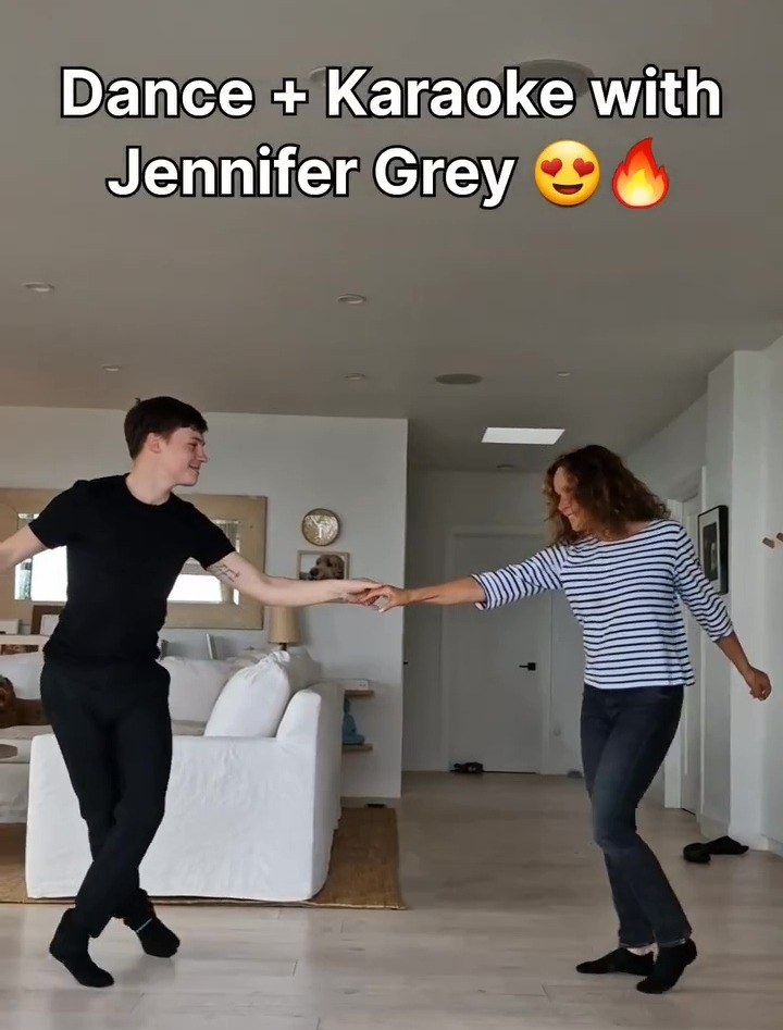 a woman and a boy are dancing in a living room with the caption " dance + karaoke with jennifer grey "