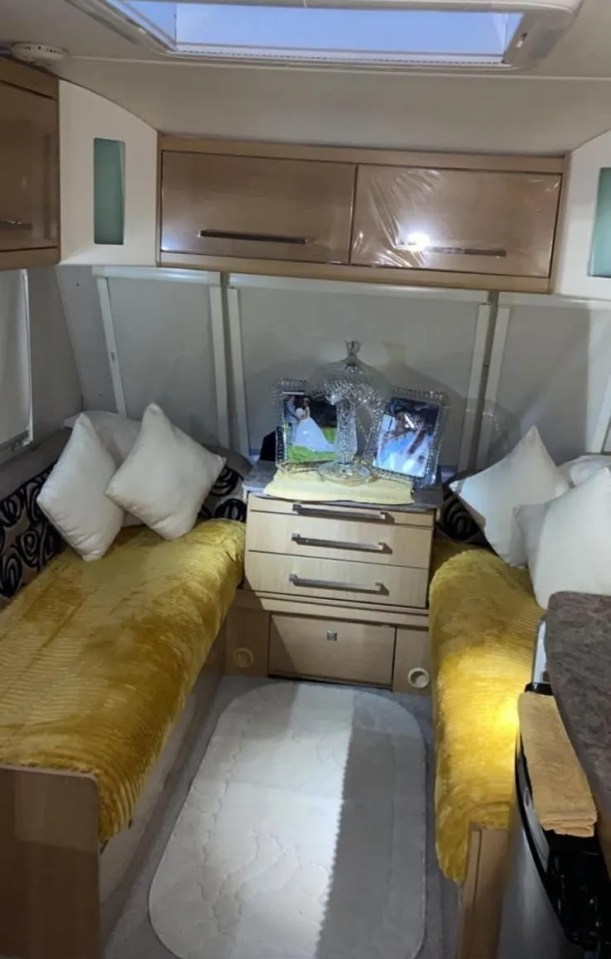 a caravan with two beds and a nightstand