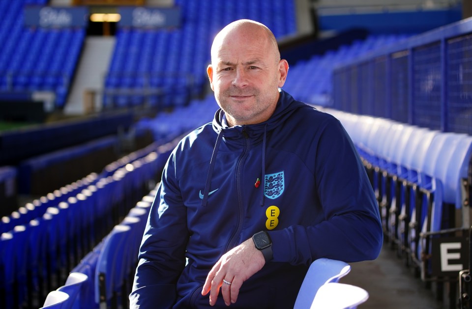 a bald man wearing a blue nike jacket with the england logo on it