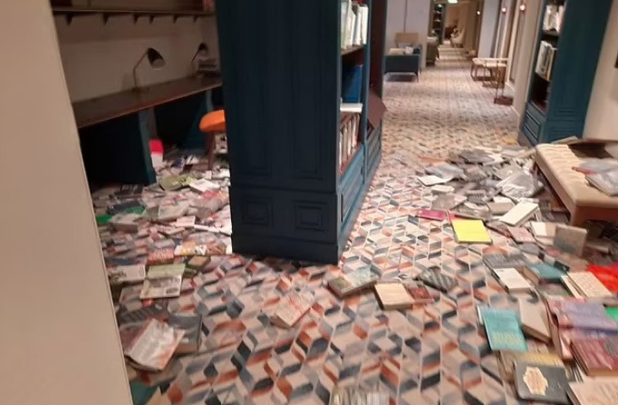 A bookshelf inside the vessel has been shaken around tipping all the books out