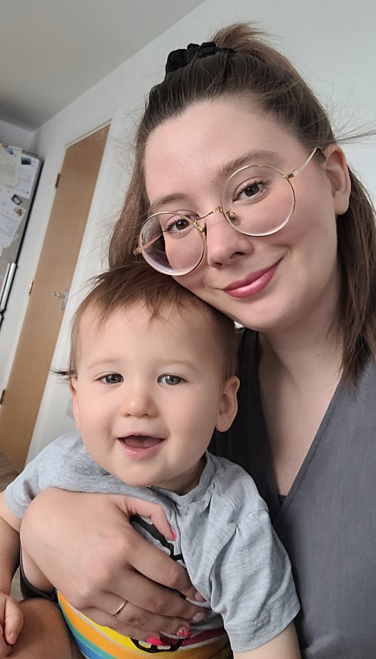 a woman wearing glasses holds a baby in her arms