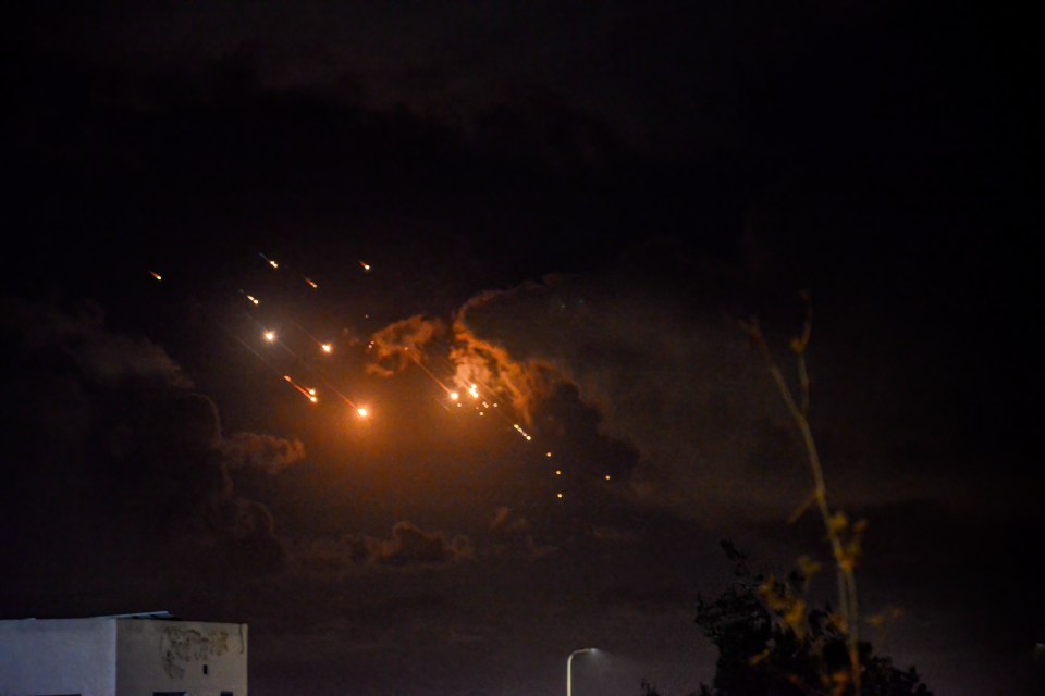 fireworks are lit up in the night sky above a building