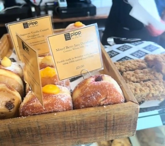 a display of mixed berry jam doughnuts in a wooden box