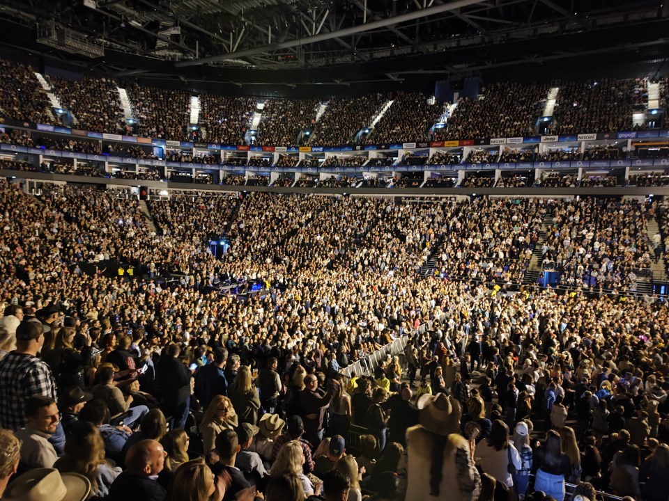 a large crowd of people in a stadium with advertisements for coca cola