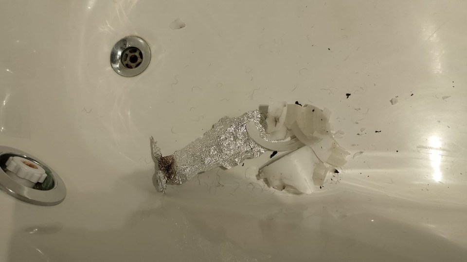 a bathtub with a broken piece of aluminum foil in it