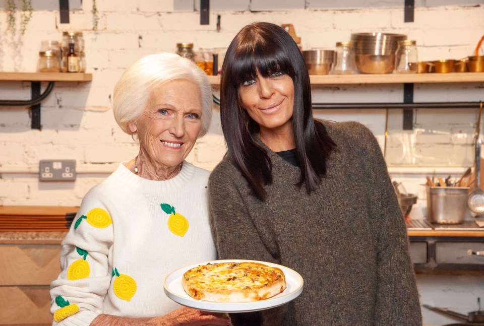 two women standing next to each other holding a plate of food