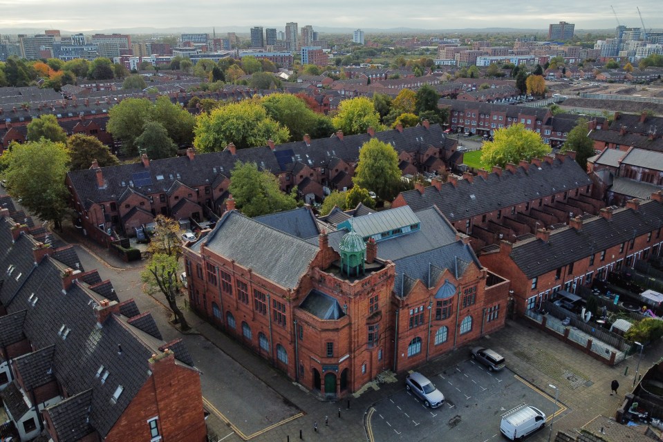 an aerial view of a residential area with a large red building in the middle