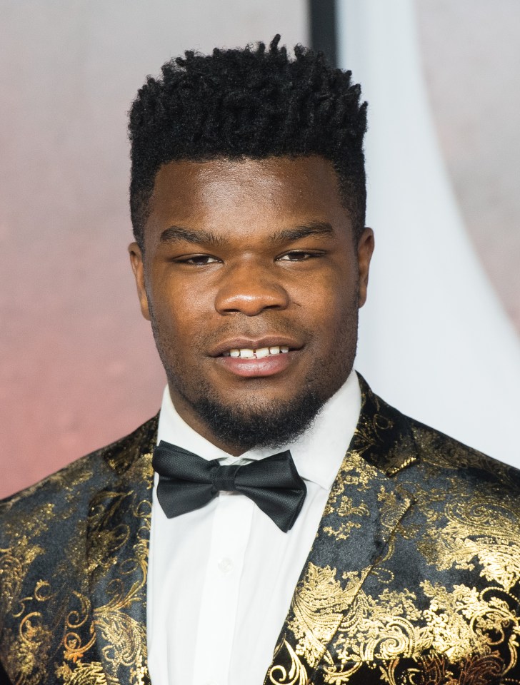 a man wearing a black and gold suit and bow tie