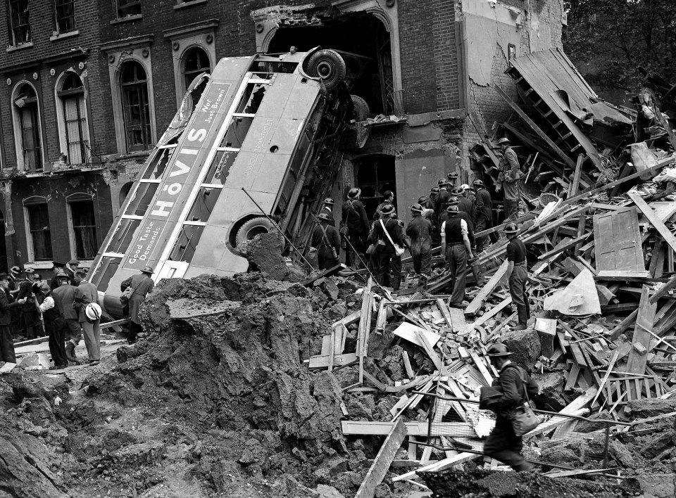 An upturned bus in the middle of London shows the horrific aftermath of a bombing in 1940