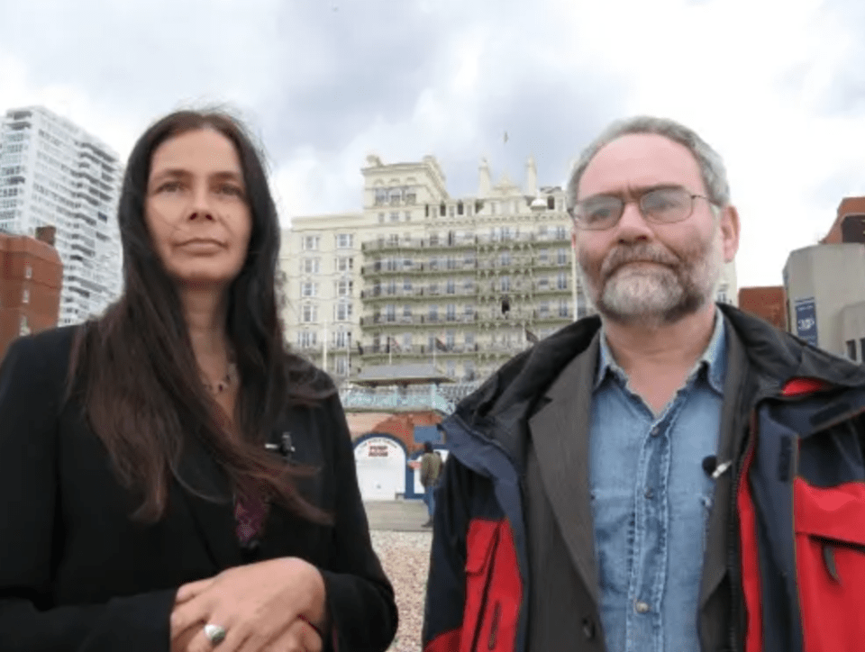 a man and a woman are standing in front of a large building