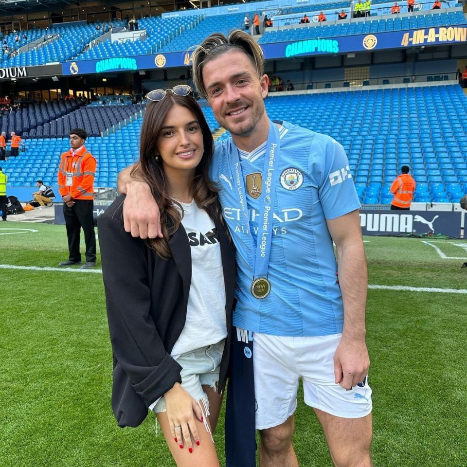 a man and a woman pose for a picture on a soccer field